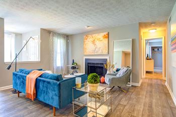 a living room with a blue couch and chair in front of a fireplace